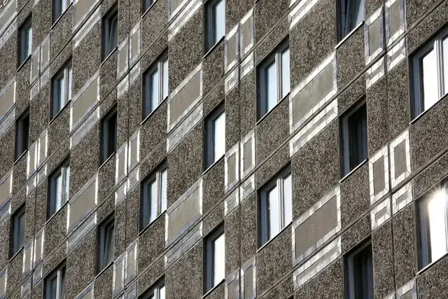 Elewacja bloku z prefabrykatów betonowych z regularnym rastrem okien